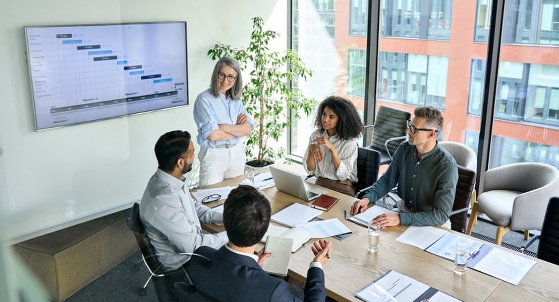Diverse corporate team in a meeting room discussing reports.