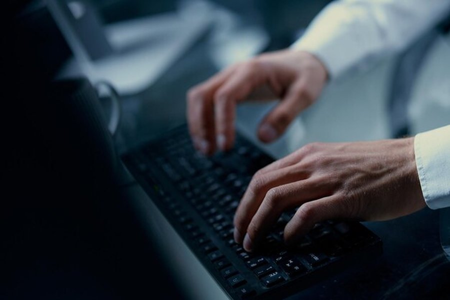 Persona usando un teclado, interactuando con tecnología para crear texto.