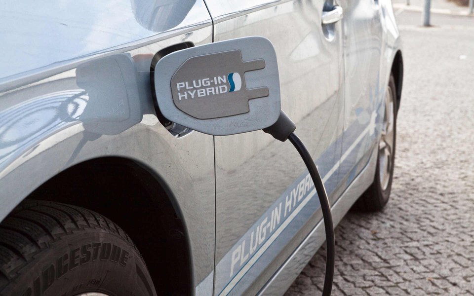 A plug-in hybrid being charged, illustrating its reliance on external power.