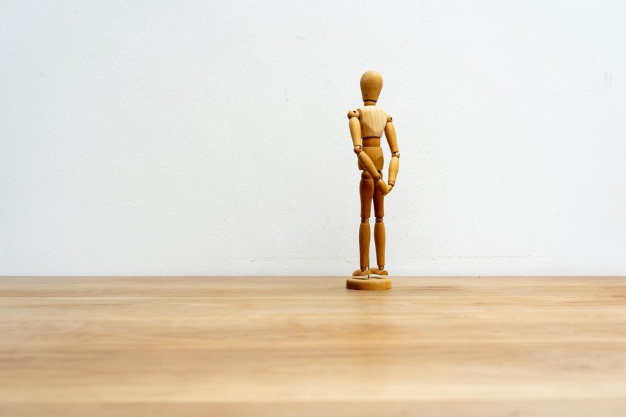 Illustration einer abstrahierten Figur, die vor einem Bildschirm mit grafischen Darstellungen steht.