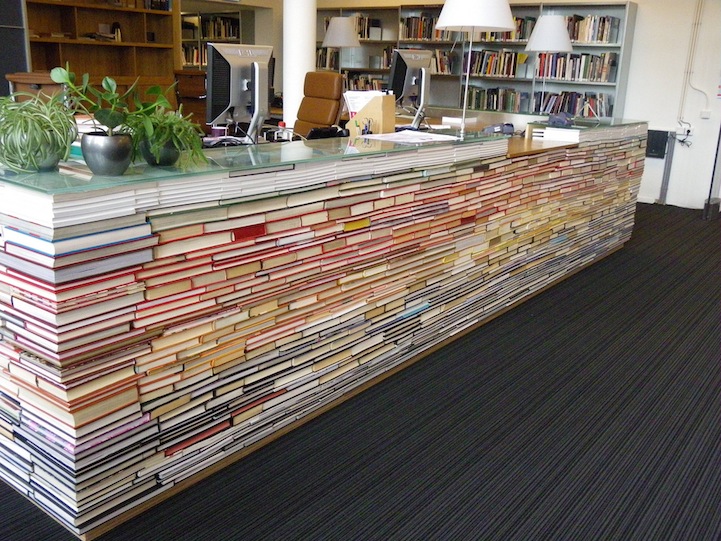 landscape of books and digital devices on a wooden desk