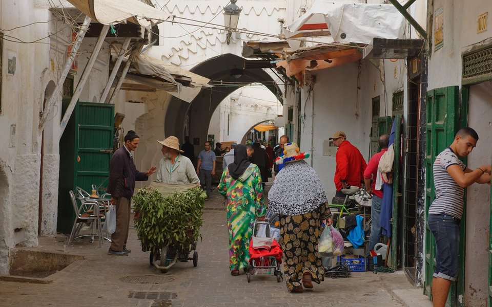 Street market scene in Tetouan, Morocco with people shopping.