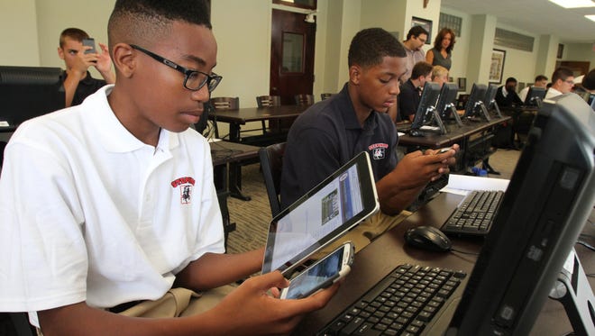 students studying with textbooks and digital devices