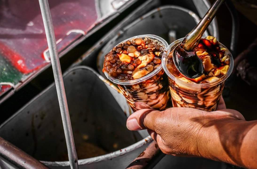 Filipino street food vendor with taho cups