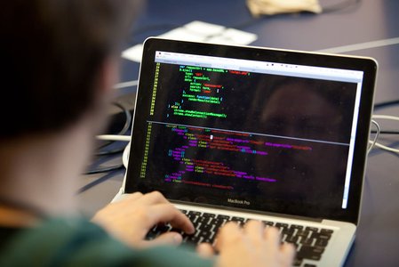 person writing code on a laptop