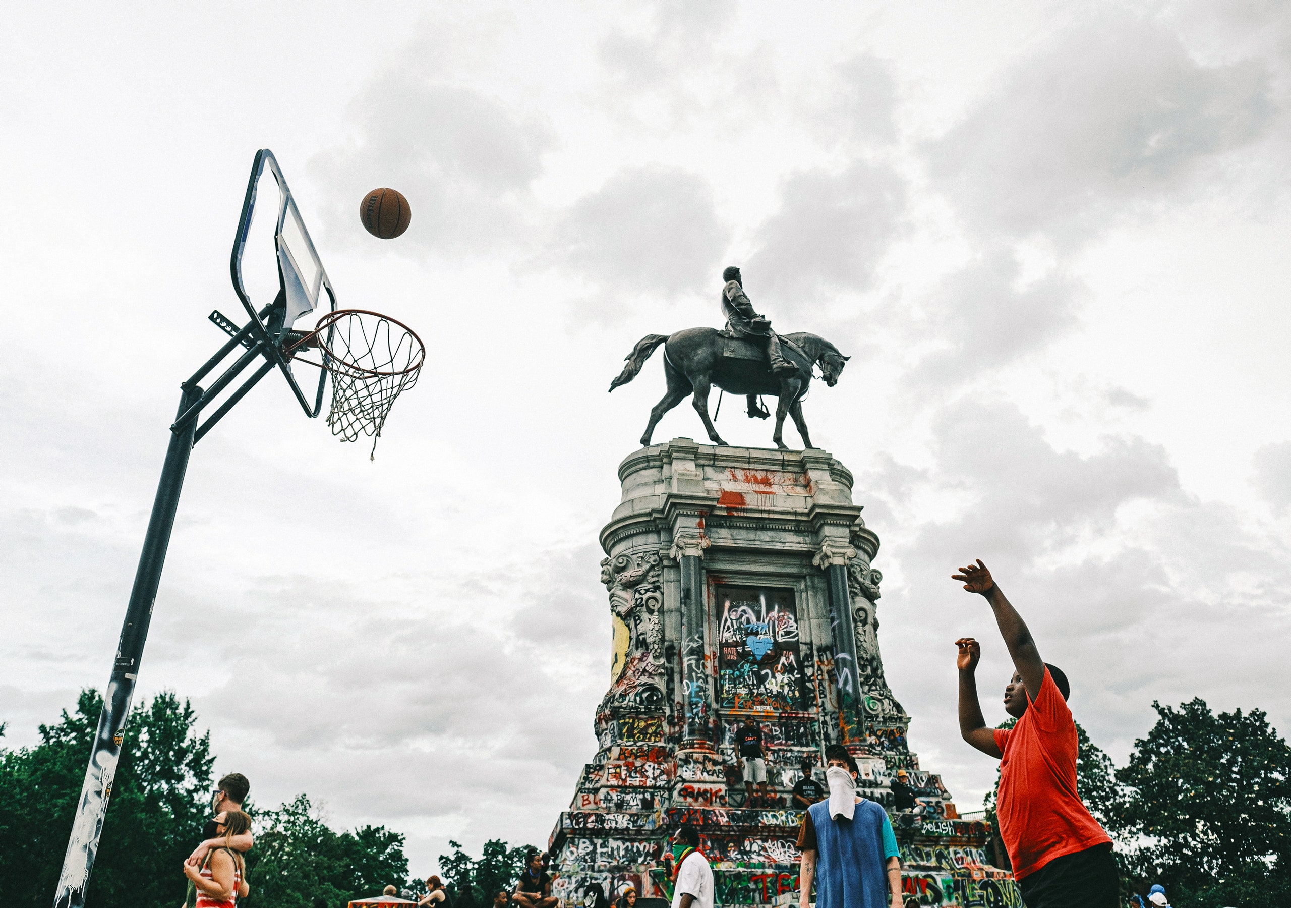 modern healthcare protest, symbolic statues, busy urban public space