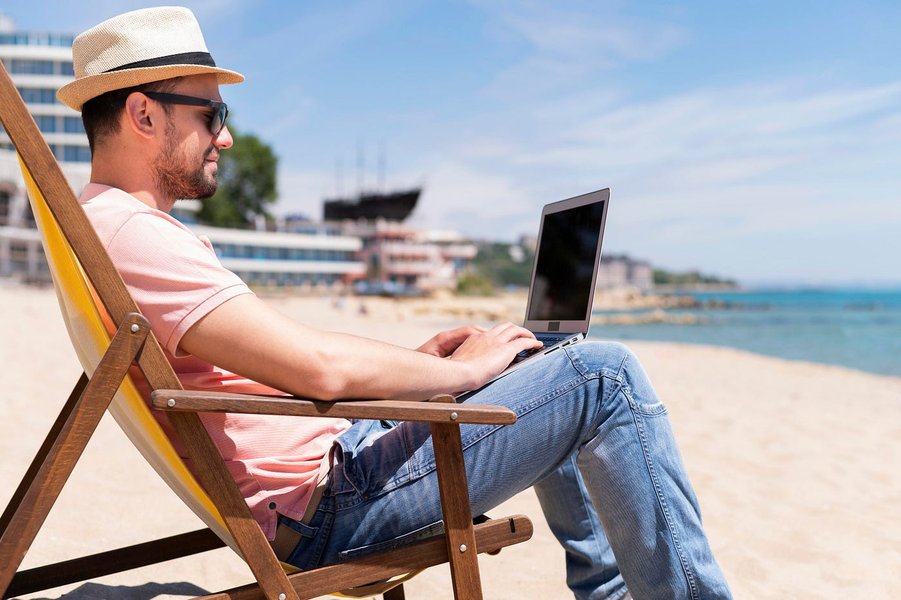 Person working on a laptop in a cafe, illustrating the digital nomad lifestyle often associated with online passive income.