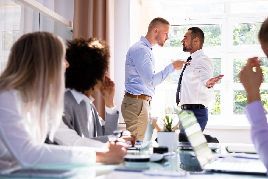 Two colleagues arguing intensely in an office setting
