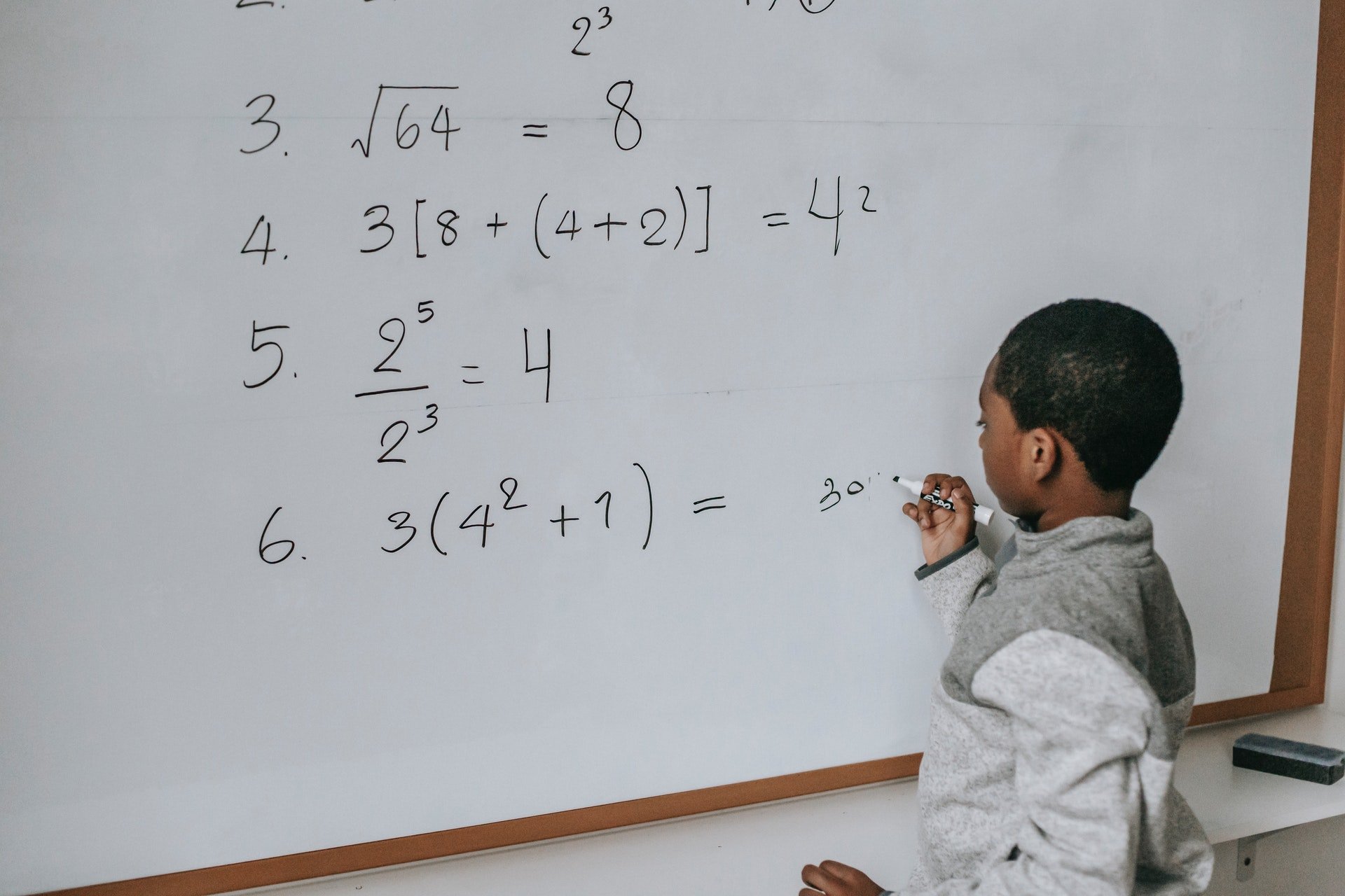 students working with math equations on a board