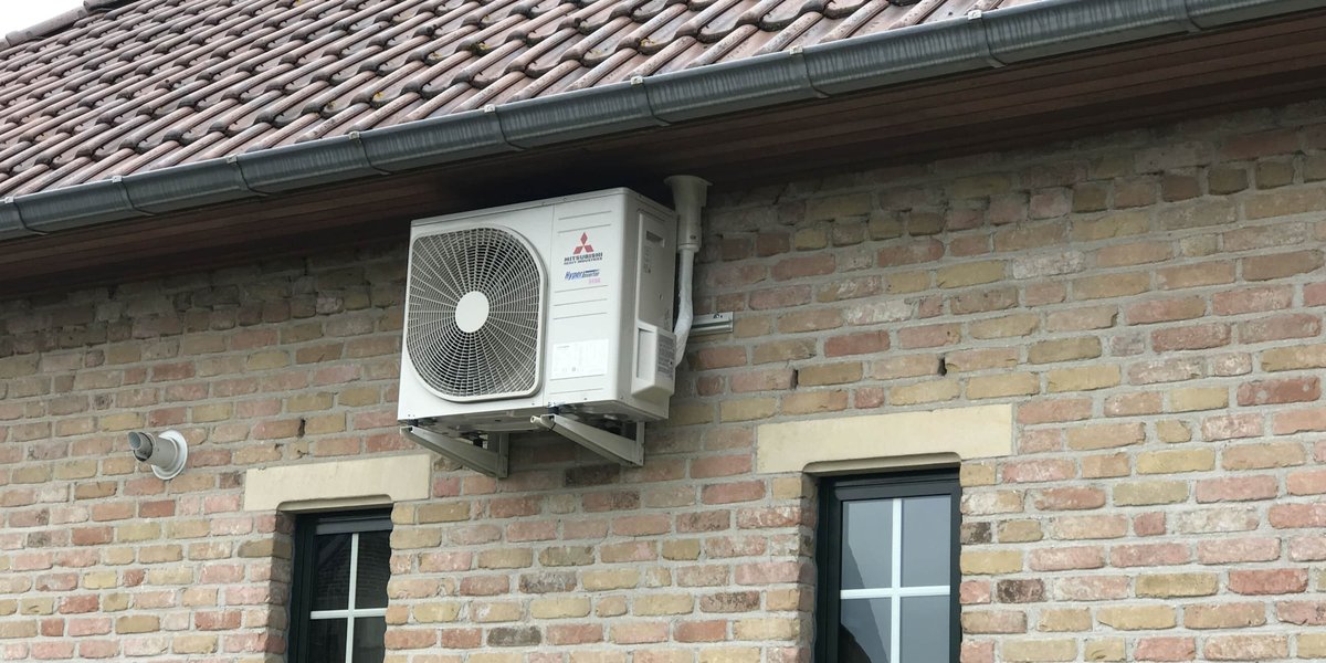 Buitenunit van een split airco geplaatst op een muurbeugel