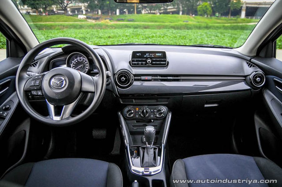 Silver 2015 Mazda2 driving on a winding road