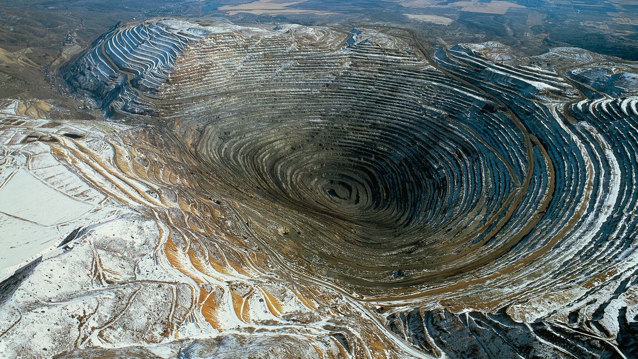open pit mining landscape with machinery and natural scenery