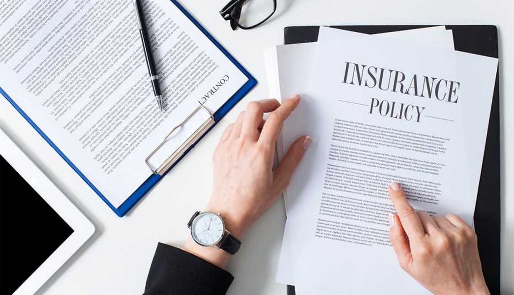 A woman reading an insurance policy document intently, symbolizing the complexity of insurance language, especially concerning anti-concurrent causation clauses.