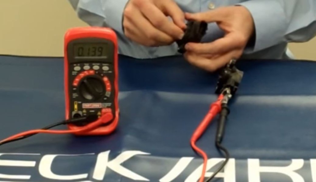 A technician inspecting a dirty throttle body with visible carbon buildup.