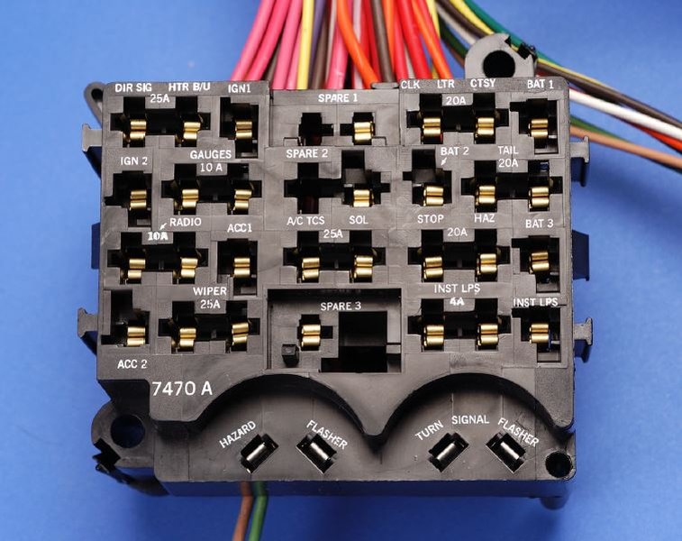 Close-up of a vehicle's fuse box with various fuses