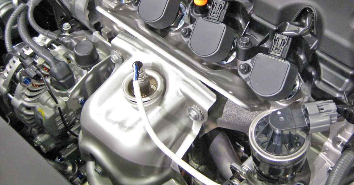 A mechanic utilizing a specialized oxygen sensor socket to replace an O2 sensor.