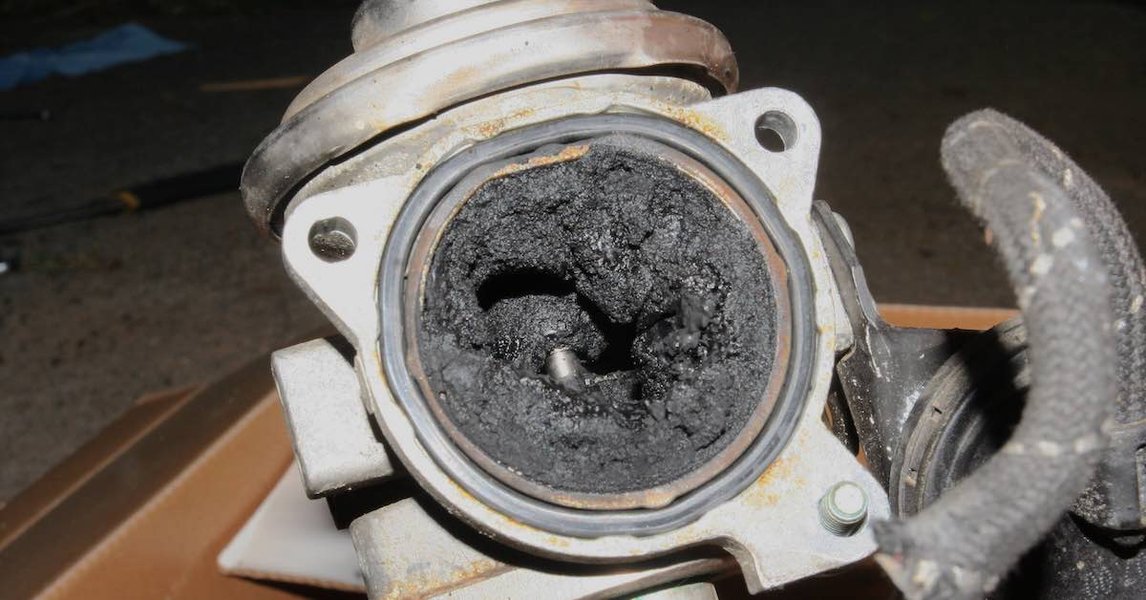 Various tools and cleaning supplies laid out for an EGR valve cleaning procedure.