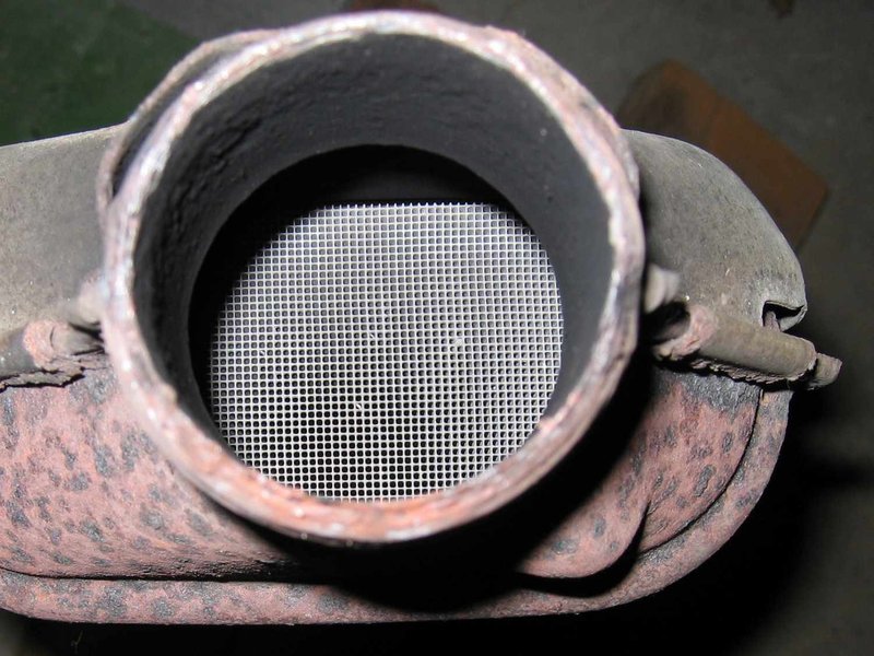 A cutaway view of a catalytic converter, revealing its honeycomb structure and precious metal coatings.