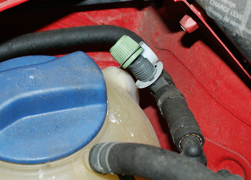 A professional technician performing a smoke test on a vehicle's EVAP system to locate a leak.