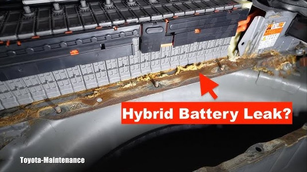 Close-up of a Toyota hybrid battery pack with visible signs of wear and electrolyte leakage