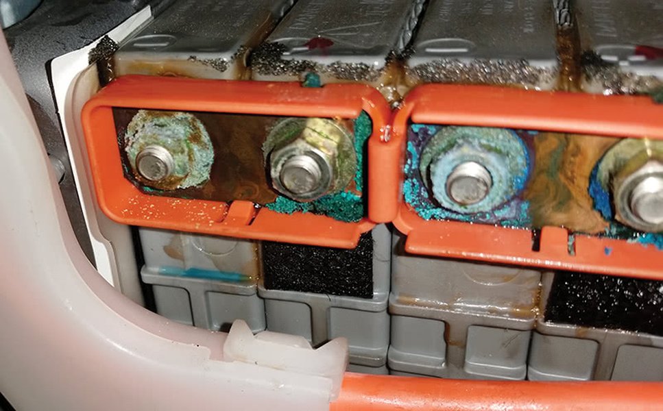 Close-up of a high-voltage battery module showing electrolyte leakage, a common cause of insulation failure