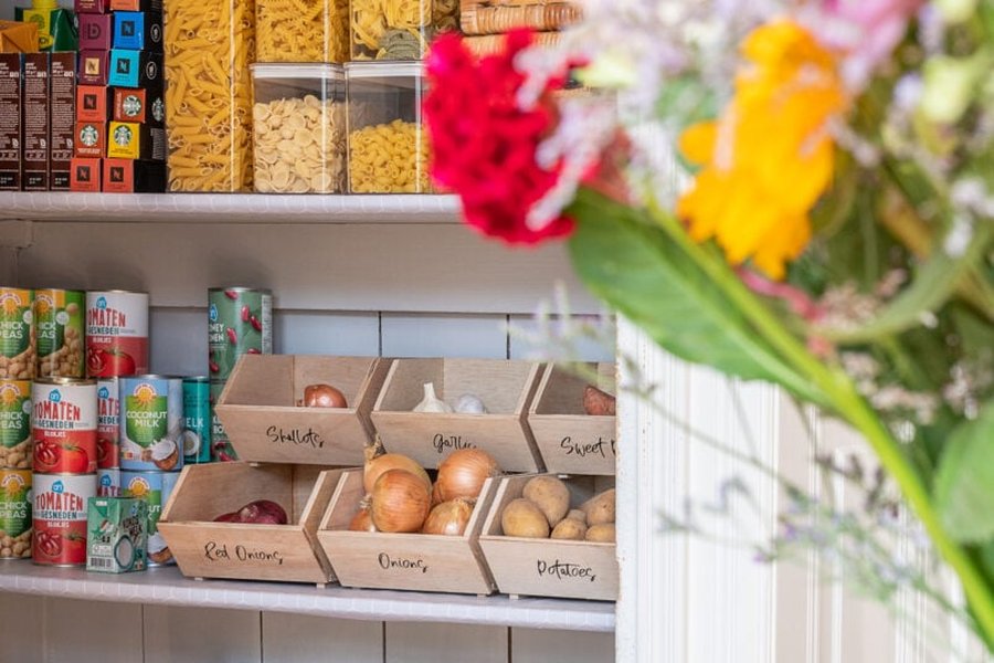 Stackable storage bins used in a pantry to organize various items.