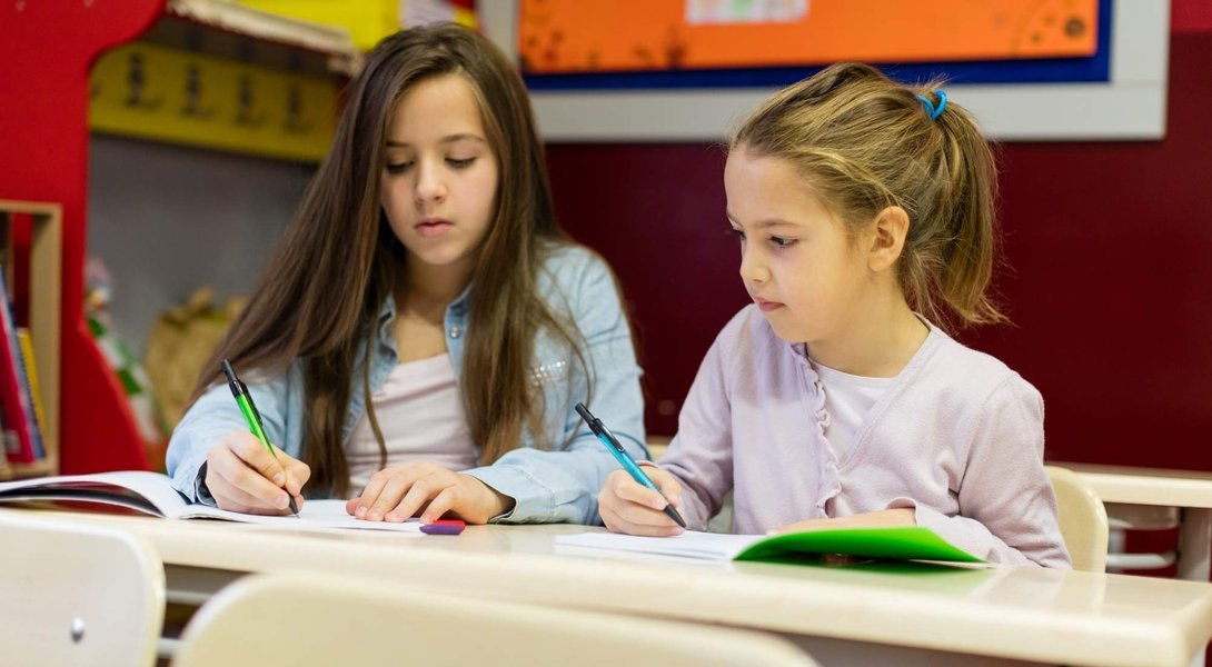 Seorang siswa menjelaskan konsep kepada temannya dalam sesi peer tutoring