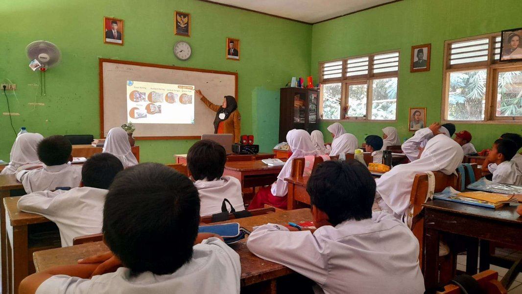Seorang kepala sekolah sedang berdiskusi dengan guru