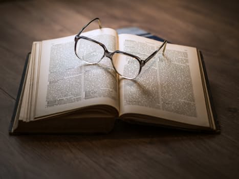 open book with scholarly notes on wooden desk