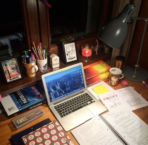 evening work desk with academic papers and laptop