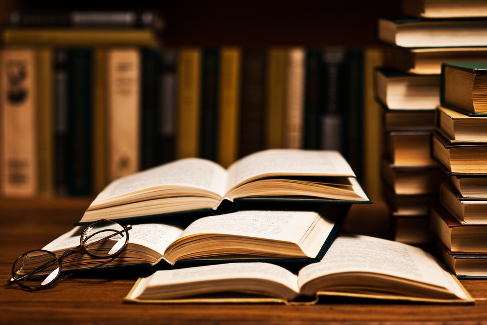 open book on desk with glasses