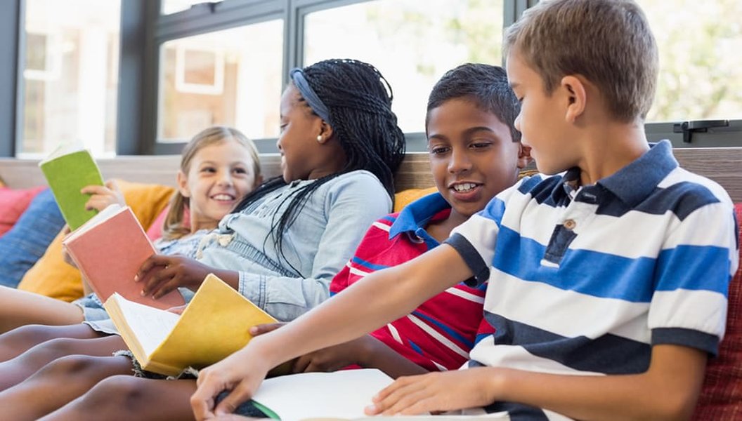 Elementary students reading together on a couch