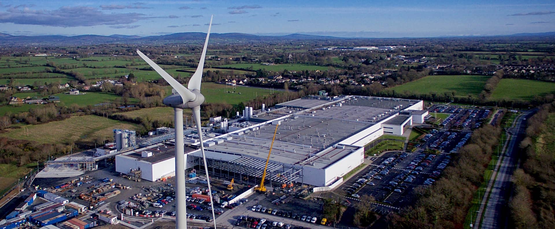 landscape with industrial facility and renewable energy wind turbines