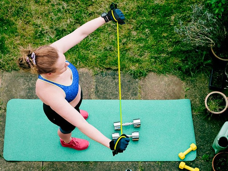 Person performing resistance band chest fly exercise