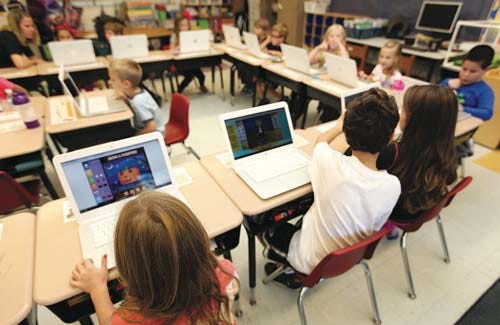 students using digital devices in classroom