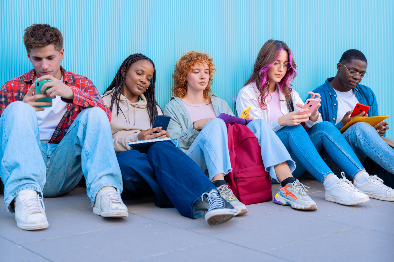 young people using smartphones outdoors