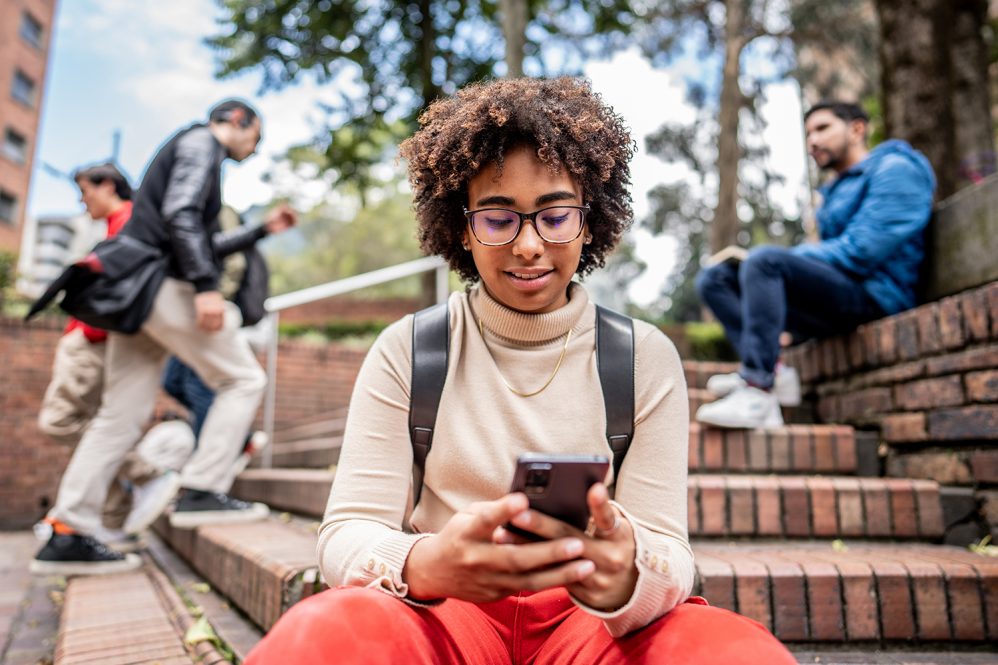 students using social media outdoors