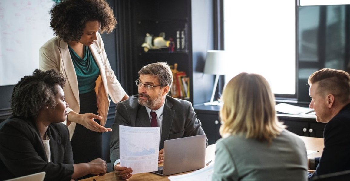 People sitting around a conference table in discussion, potentially mediation