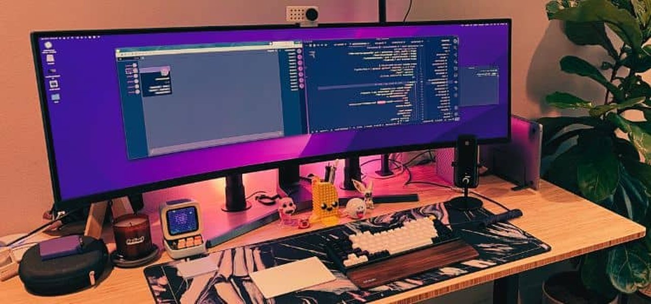 Programmer desk setup with multiple monitors showing code
