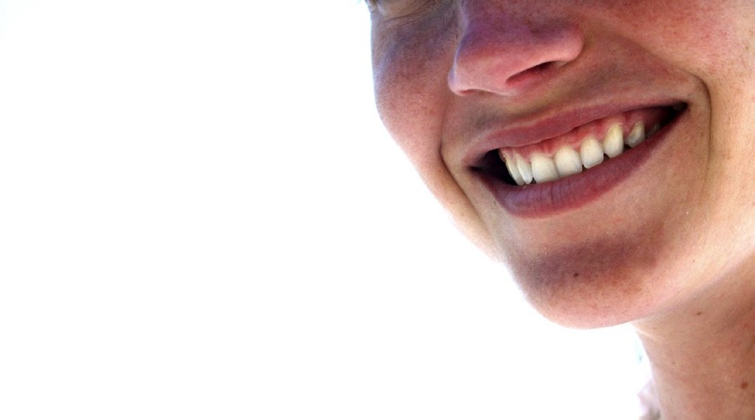Uma pessoa sorrindo, com foco na expressão facial de felicidade.