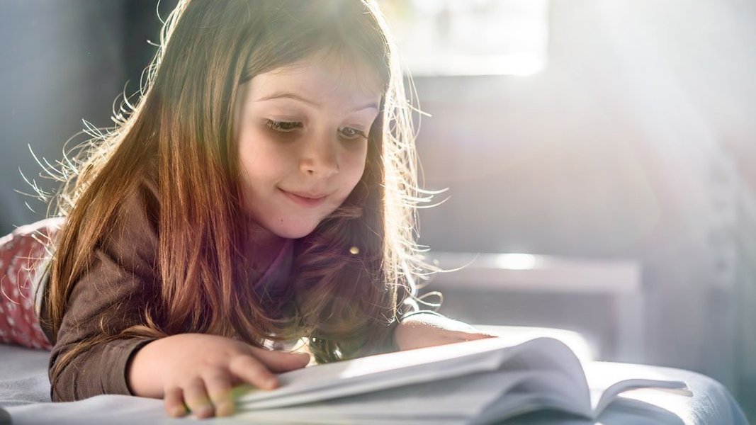 Child reading independently in a comfortable home setting