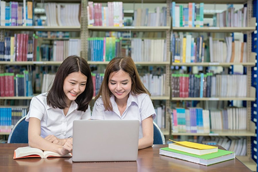 students using laptops in university library