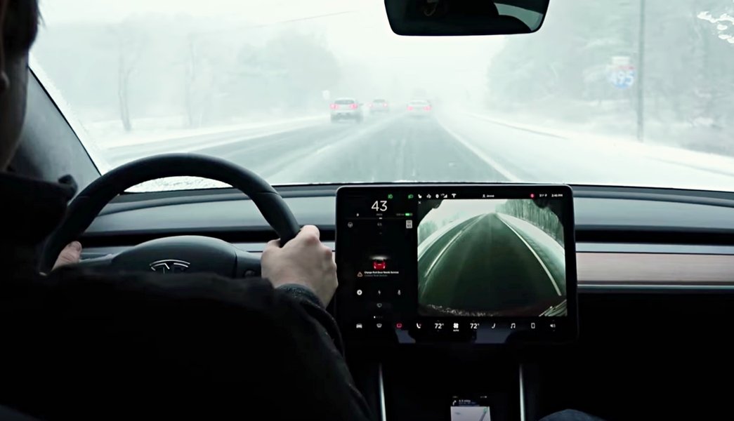 The Tesla Model 3's interior, showcasing its touchscreen which controls climate and other features impacting range.