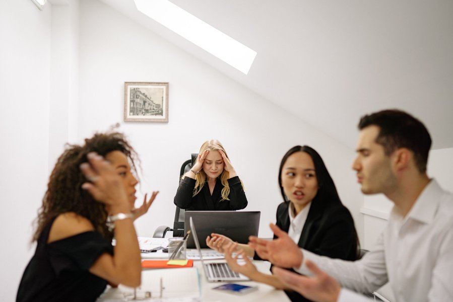 Diverse group of colleagues collaborating around a table, indicating workplace dynamics