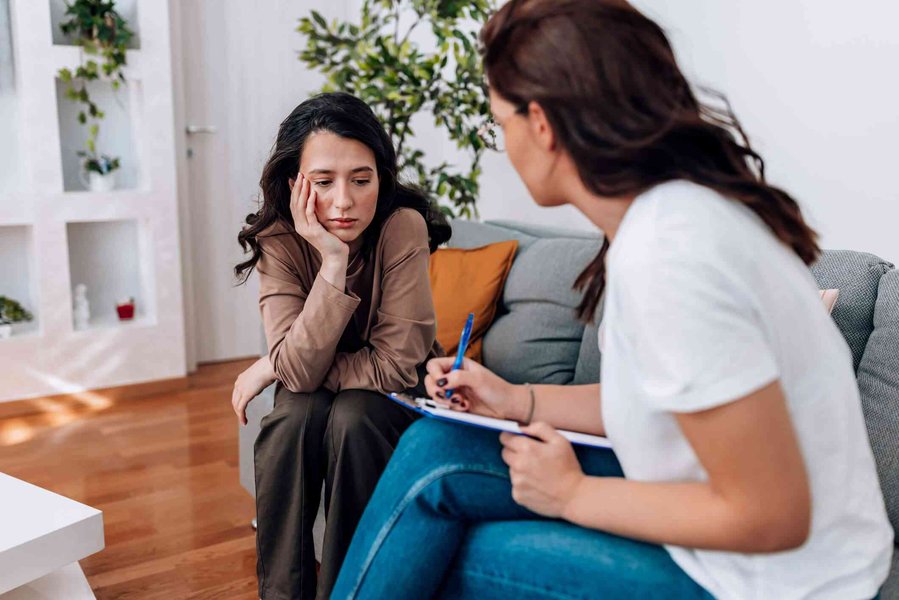 Therapist taking notes while listening to a client