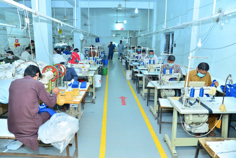 Rows of industrial sewing machines in a garment factory