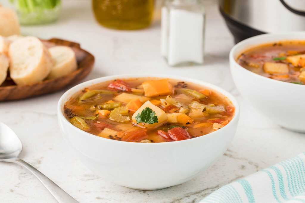 fresh vegetable soup in a bowl on wooden table