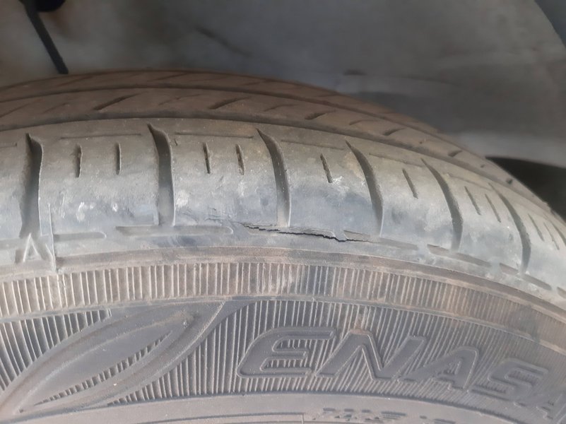 Visible cracking on a tire sidewall, a clear sign of rubber degradation or dry rot.
