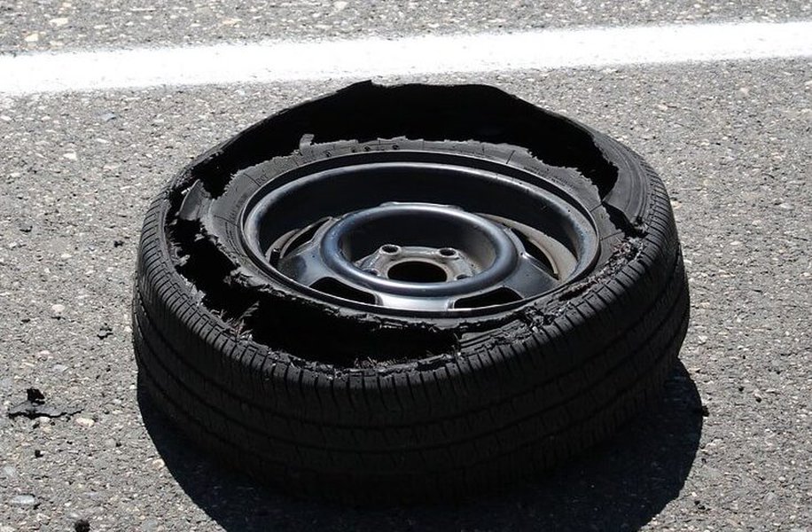 A severely damaged tire after a blowout, highlighting the dangers of neglected tire health.
