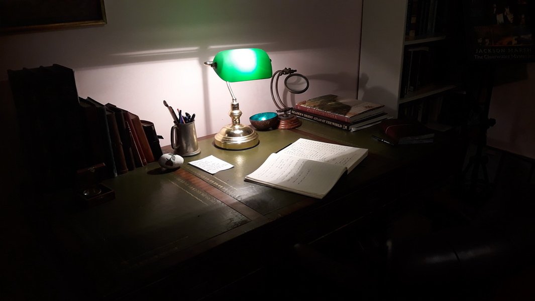 Author's desk with laptop, notebooks, and coffee